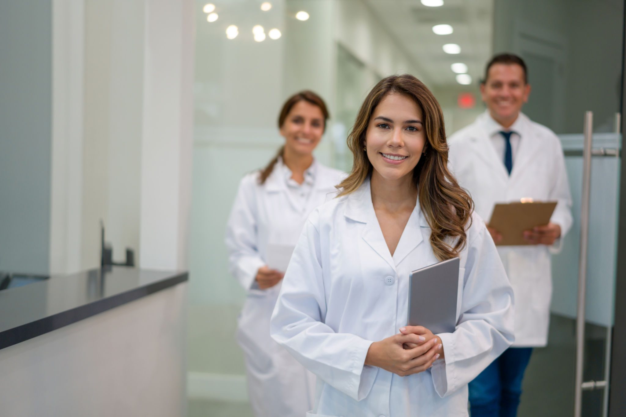 Doctors smiling in a medical office hallway.